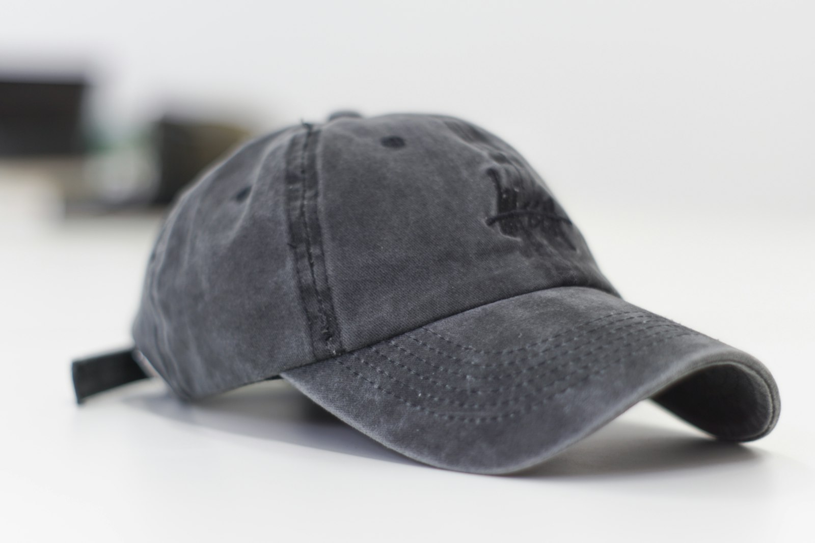 A distressed unstructured cap on a clean studio surface